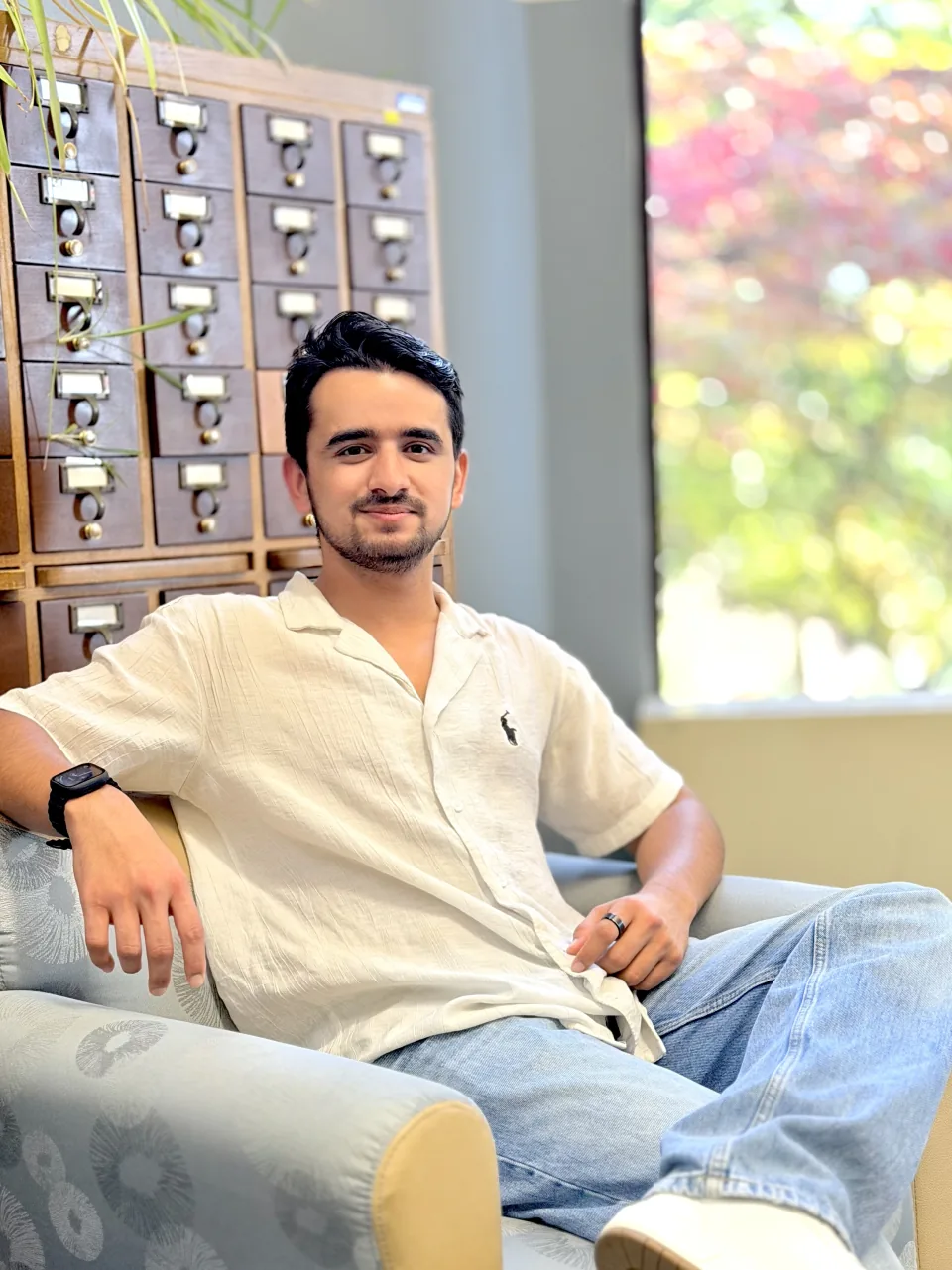 Nishar Miya, seated beside a sunlit window